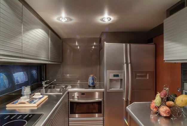 A modern kitchen featuring energy-efficient appliances, such as a stainless steel refrigerator with an Energy Star label, and LED lighting fixtures.