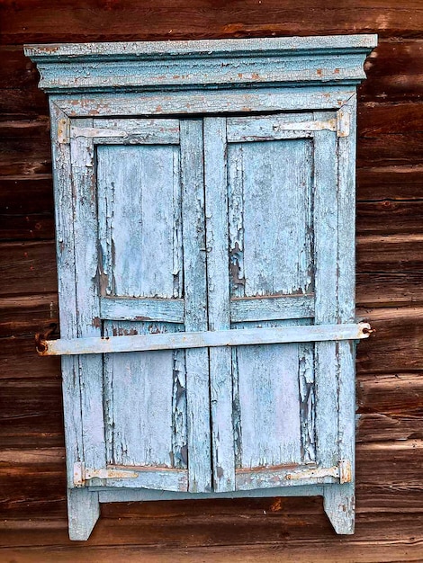 A cleverly upcycled headboard crafted from old wooden doors, painted in a distressed white finish. The headboard is adorned with vintage knobs and serves as the focal point in a rustic-chic bedroom. The doors retain their original character, adding a unique and charming touch to the space.