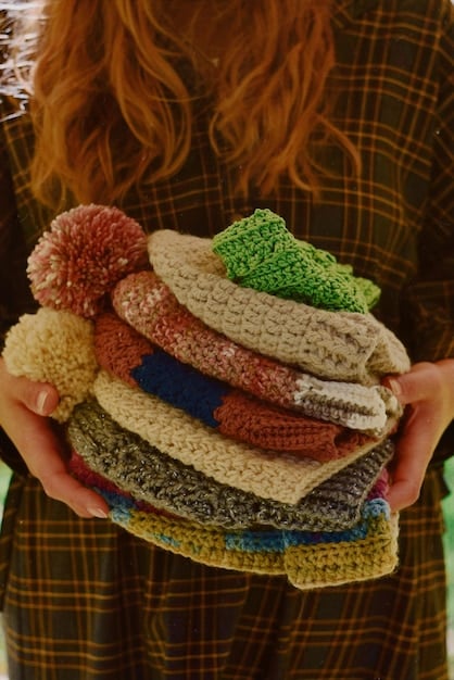 A close-up shot of a hand sorting through a rack of vintage clothing in a brightly lit thrift store. The clothes are diverse in color and style, representing different eras.