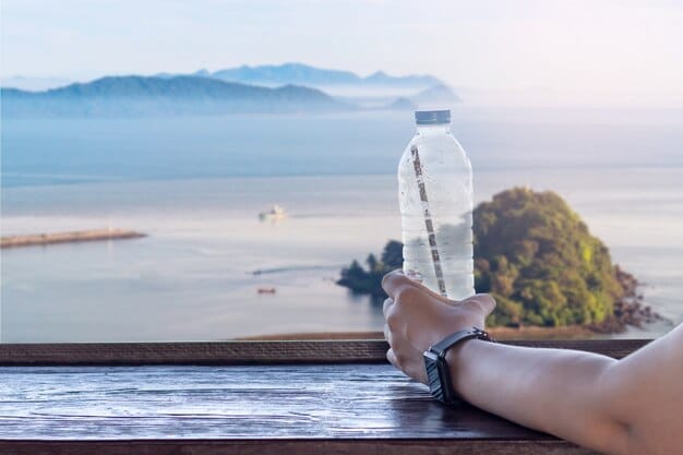 A traveler using a reusable water bottle at a scenic overlook, with a clear emphasis on avoiding single-use plastics.