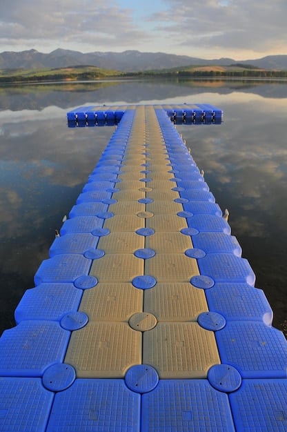 A detailed close-up of a floating solar panel on a lake, showing the panel structure and the floating platform. The water is calm and clear, with gentle ripples around the platform. The image highlights the construction and technology of the floating solar farm.