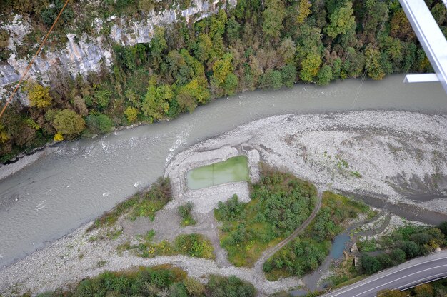 An aerial view of a hydroelectric dam with graphical overlays illustrating the real-time monitoring of water flow and AI-driven adjustments to optimize energy generation while minimizing environmental impact.