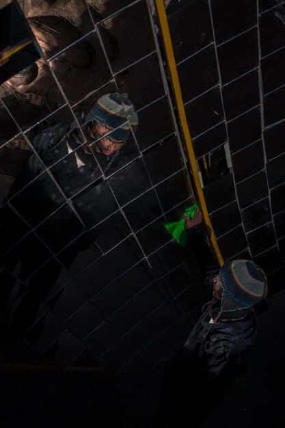 A close-up shot of a manufacturing plant, depicting workers in clean suits assembling solar panels on a production line using robotic arms. The scene highlights precision, technology, and the manufacturing aspect of the solar industry.