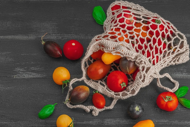 A shot showcasing a variety of reusable shopping bags and mesh produce bags filled with colorful fruits and vegetables at a farmer's market.