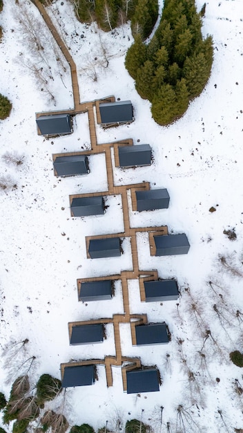 A drone shot of a solar panel installation completely covered in snow after a heavy snowfall, with only the edges of the panels visible.