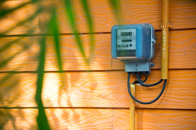 A close-up shot of a smart meter installed on the side of a house, displaying real-time energy usage data, with a focus on the digital display and the surrounding electrical infrastructure.