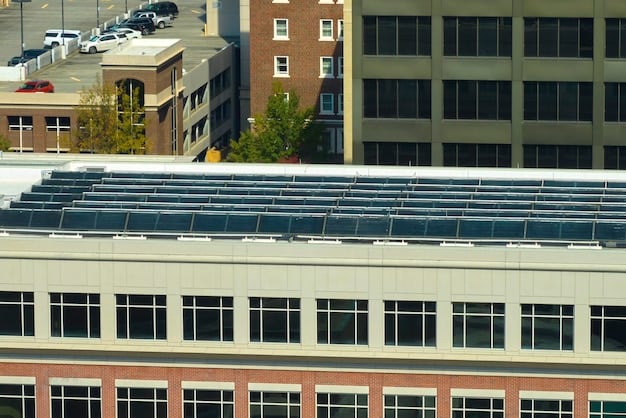 A row of solar panels installed on the roof of a commercial building, under a bright sunny sky. The panels are neatly arranged and angle towards the sun, showcasing a clean and sustainable energy solution for large buildings.