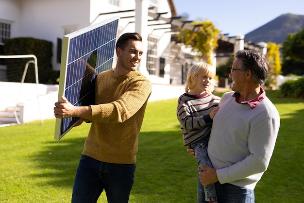 A family standing in front of their home with newly installed solar panels, smiling and pointing towards the panels, signifying the personal economic benefits of renewable energy.