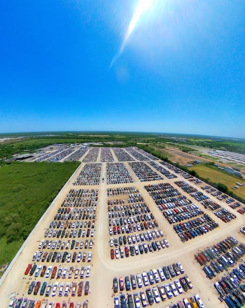 An aerial view of a city showcasing both traditional gas-powered vehicles and electric vehicles. The image highlights the presence of charging stations in various locations throughout the city, such as residential areas, commercial districts, and public parking lots.