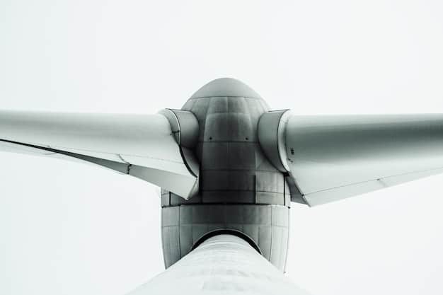 A close-up shot of a large wind turbine blade being manufactured in a factory. The image focuses on the precision and scale of the manufacturing process and the technology involved.